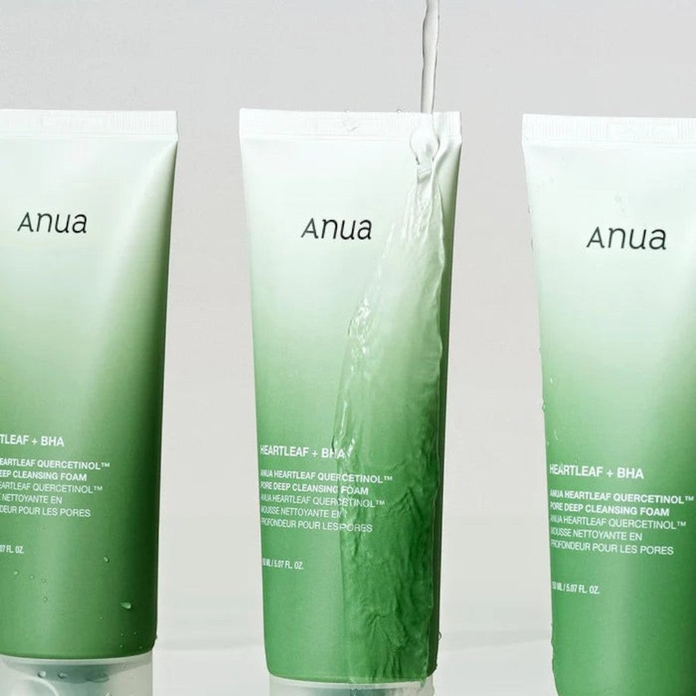 Skin TOGO Anua Heartleaf Quercetinol Moisture Cleansing foam tubes with water splashing on a green gradient background