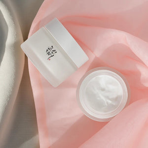 Skin TOGO Beauty of Joseon Dynasty Cream in a frosted glass jar with a white lid on a soft pink fabric background.
