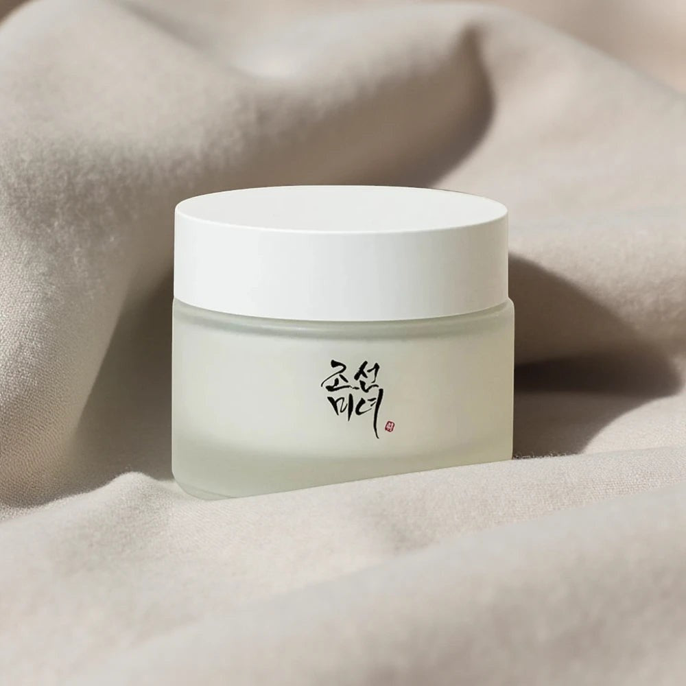 Skin TOGO Beauty of Joseon Dynasty Cream in a frosted glass jar with a white lid, set against a soft beige fabric.