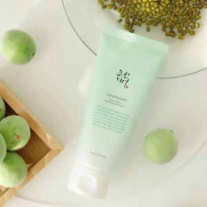 Skin TOGO Beauty of Joseon Green Plum Refreshing Cleanser tube with fresh green plums and mung beans on a white table