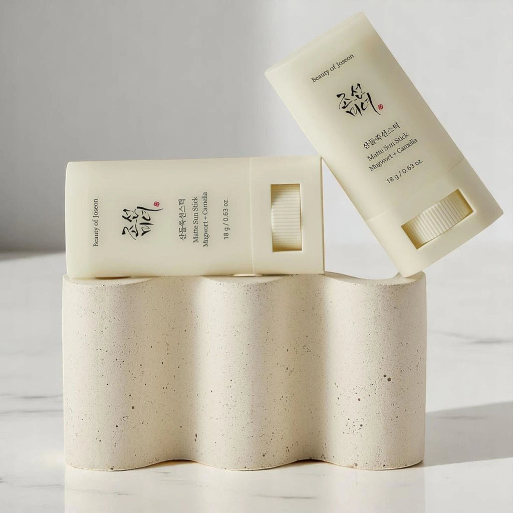 Skin TOGO Beauty of Joseon Matte Sun Stick with mugwort and camelia for SPF 50+ protection on a textured stone stand.