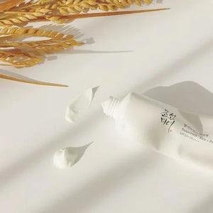 Skin TOGO Beauty of Joseon Relief Sun Rice Probiotics sunscreen tube with cream texture swatches and dried rice stalks.