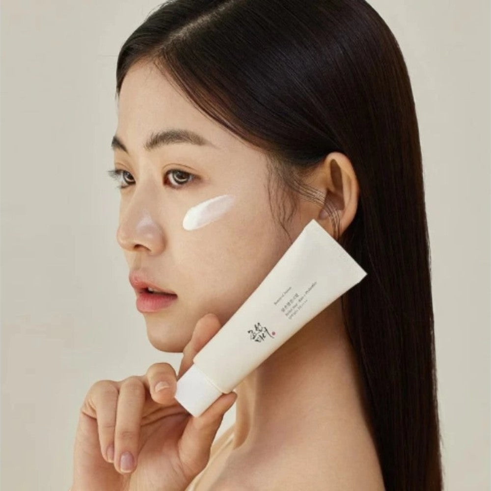 Skin TOGO model applying Beauty of Joseon Relief Sun Rice Probiotics sunscreen on her cheek in a studio setting