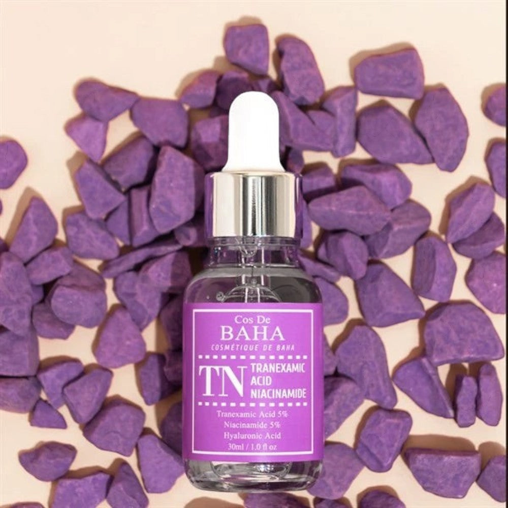 Skin TOGO Cos De BAHA TN Tranexamic Acid Niacinamide serum bottle surrounded by purple decorative stones.