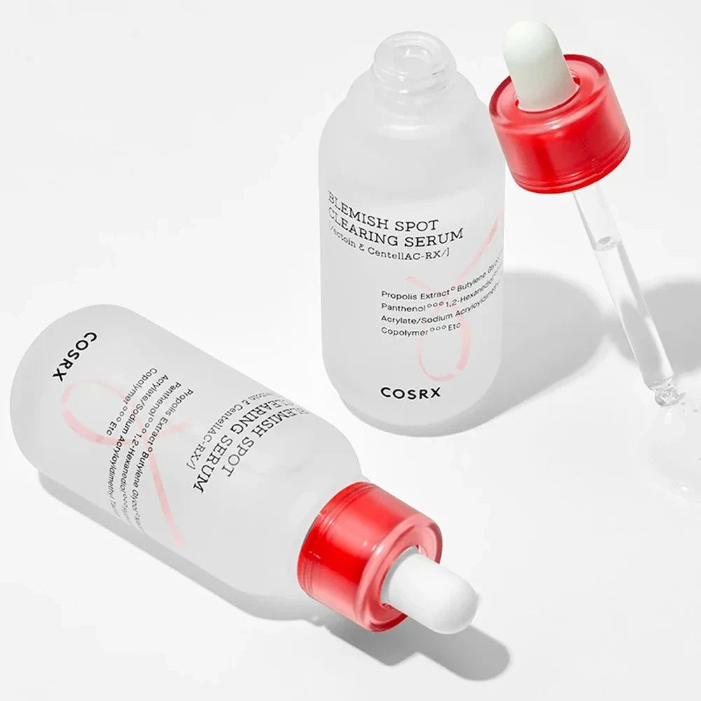 Skin TOGO COSRX Blemish Spot Clearing Serum bottles with red dropper caps and clear glass packaging on white background