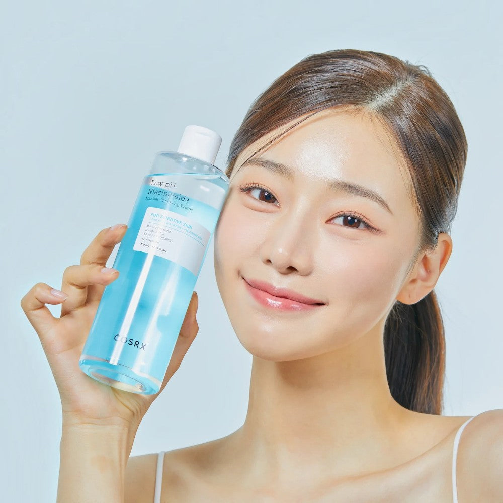 Skin TOGO model holding a bottle of COSRX Low pH Niacinamide Micellar Cleansing Water for sensitive skin