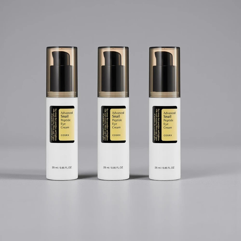 Skin TOGO Cosrx Advanced Snail Peptide Eye Cream in three white pump bottles with black caps on a grey background.
