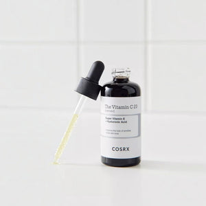 Skin TOGO Cosrx The Vitamin C 23 Serum in a dark glass bottle with a dropper on a white tiled background.