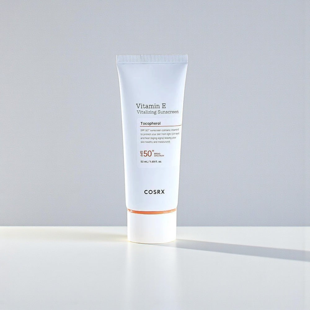 Skin TOGO COSRX Vitamin E Vitalizing Sunscreen SPF 50+ in a white 50ml tube with orange accents on a white surface.