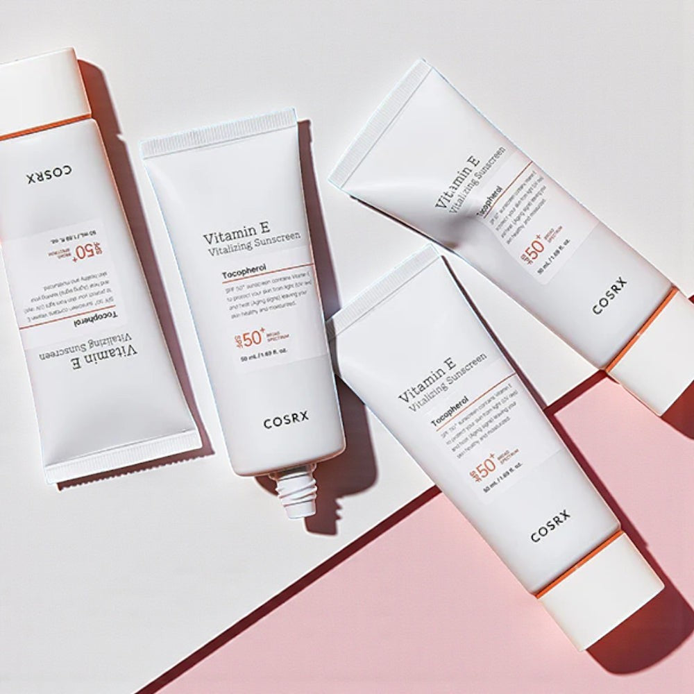 Skin TOGO COSRX Vitamin E Vitalizing Sunscreen SPF 50+ tubes arranged on a light pink surface