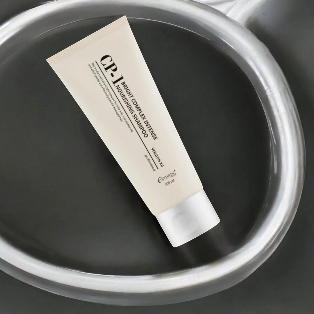 Skin TOGO CP-1 Bright Complex Intense Nourishing Shampoo 100ml tube for damaged hair on a dark reflective surface