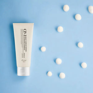 Skin TOGO CP-1 Bright Complex Intense Nourishing Shampoo in a 100ml beige tube on a light blue background.