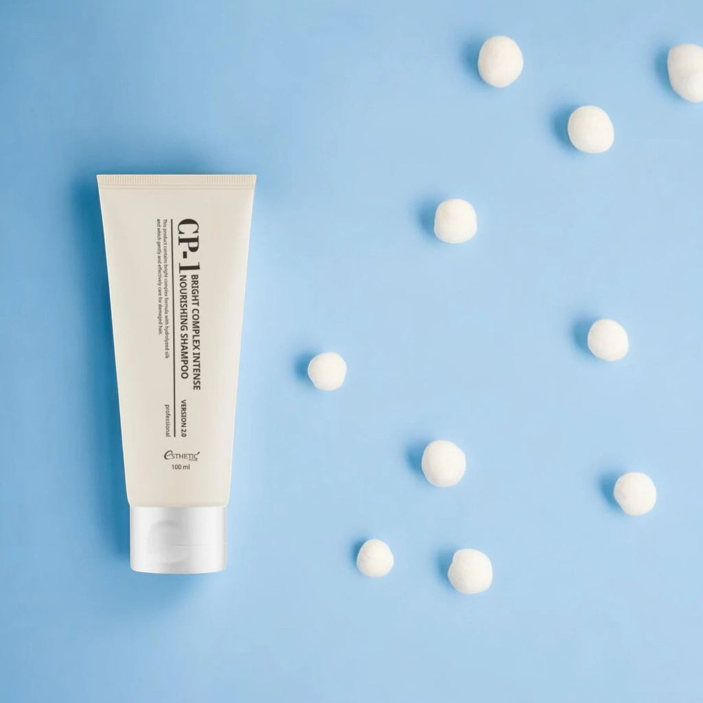 Skin TOGO CP-1 Bright Complex Intense Nourishing Shampoo in a 100ml beige tube on a light blue background.