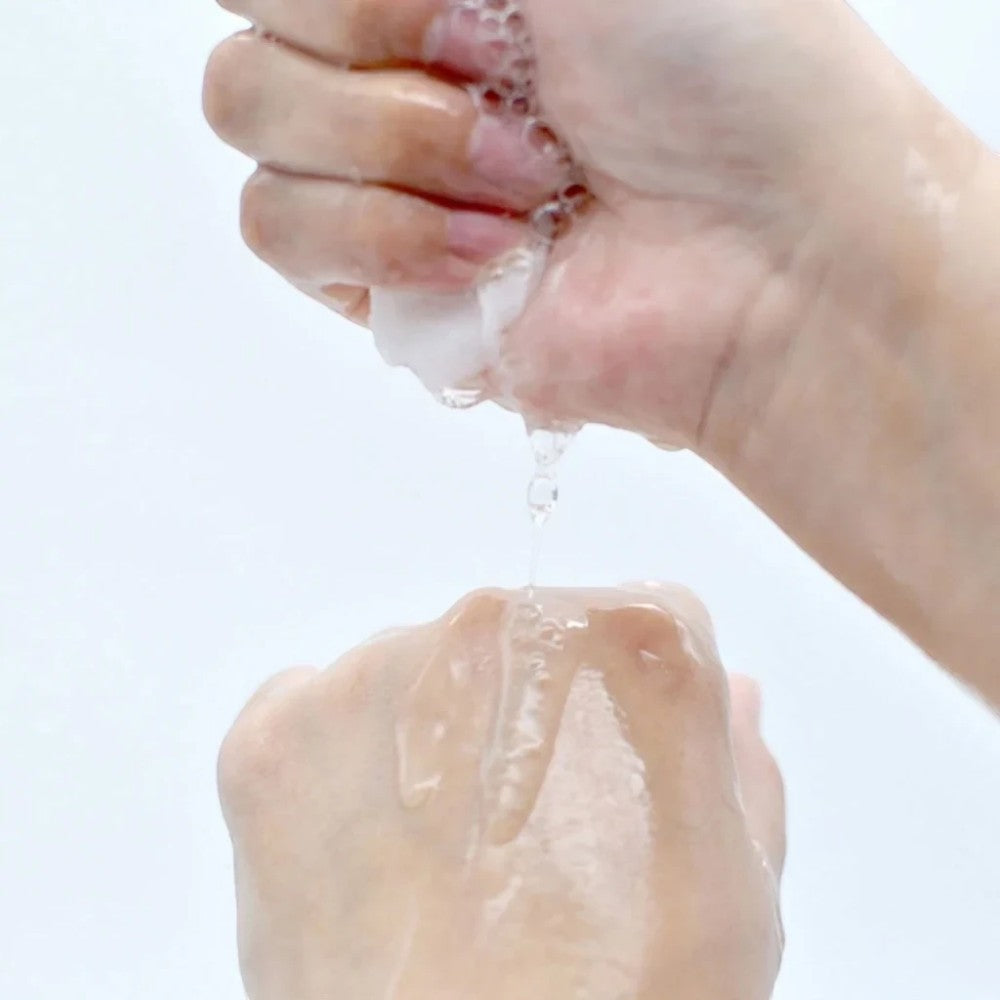 Skin TOGO Lebelage Propolis Solution Mask essence being squeezed from the sheet mask onto a hand for hydration