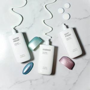 Skin TOGO MISSHA waterproof sun milk bottles with light lotion texture on a marble surface