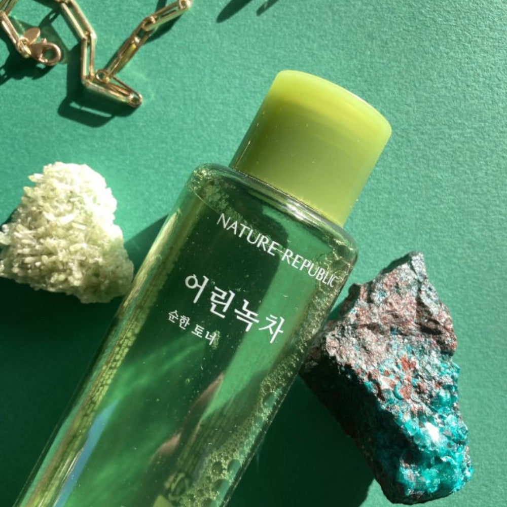 Skin TOGO NATURE REPUBLIC Young Green Tea Mild Toner in a clear green bottle with a light green cap on a green surface