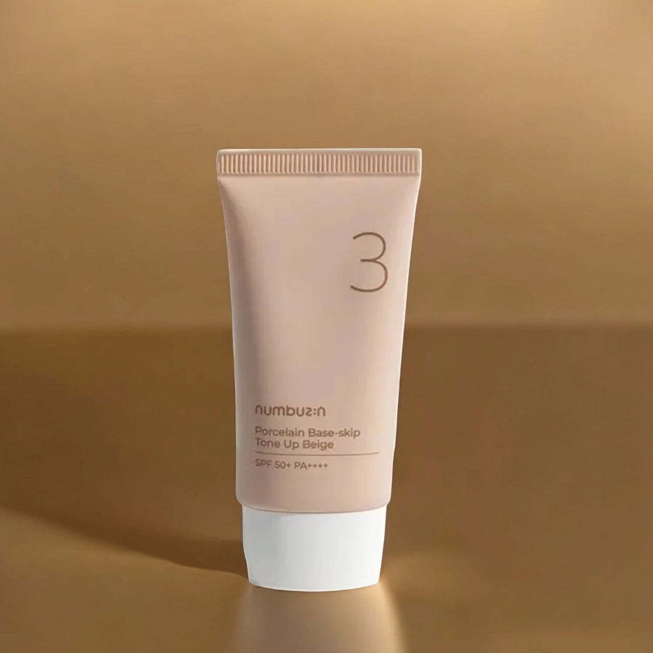 Skin TOGO Numbuzin No.3 Porcelain Base-Skip Tone Up Beige BB cream in a beige tube with white cap on a gold background