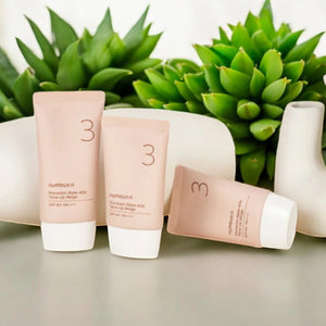 Skin TOGO Numbuzin No.3 Porcelain Base-Skip Tone Up Beige tubes arranged with decorative succulents and white vases.