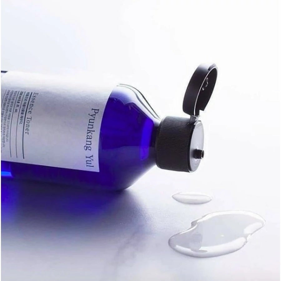 Skin TOGO Pyunkang Yul Essence Toner in a blue bottle with an open cap, showing the clear liquid texture.