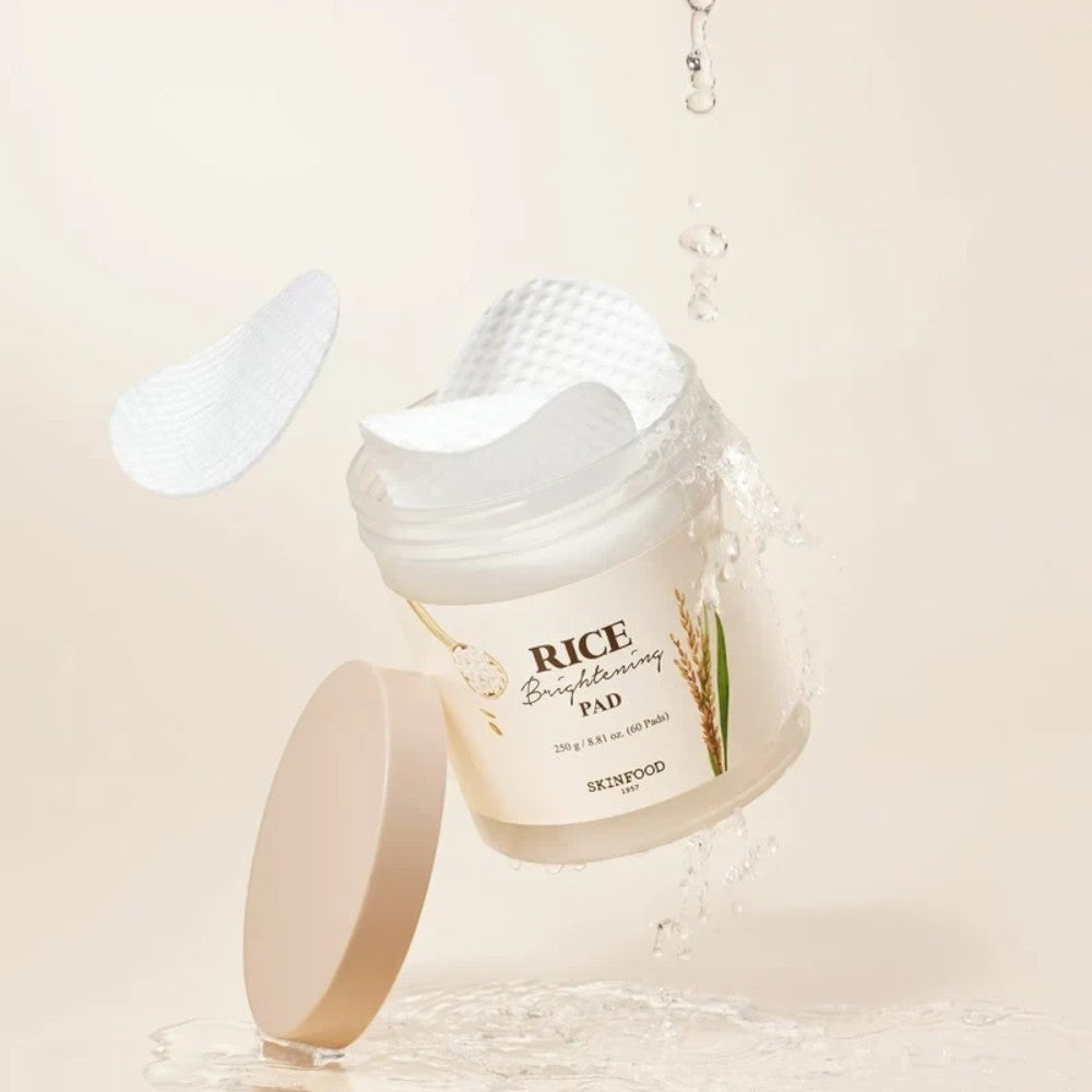 Skin TOGO SKINFOOD Rice Brightening Pads in a jar with water splashes and floating cotton pads for skin exfoliation