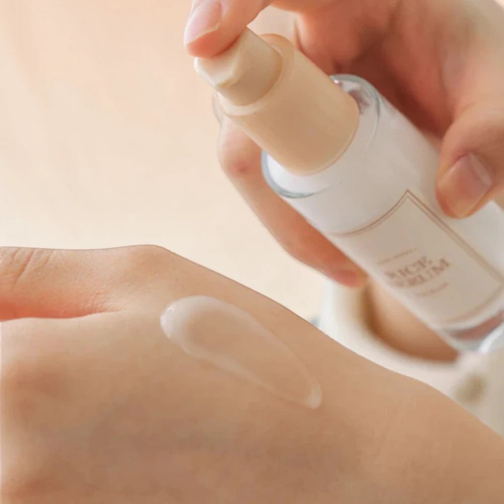 Skin TOGO I'm from Rice Serum being applied to hand, showing the lightweight, clear texture of the brightening formula.