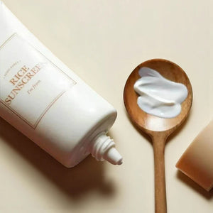 Skin TOGO I'm from Rice Sunscreen SPF50+ tube with creamy white formula on a wooden spoon