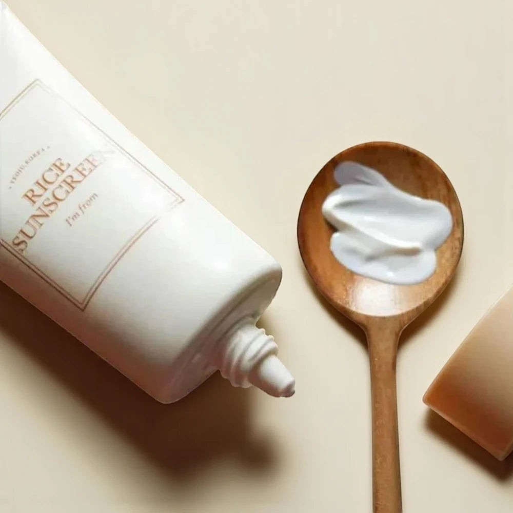 Skin TOGO I'm from Rice Sunscreen SPF50+ tube with creamy white formula on a wooden spoon