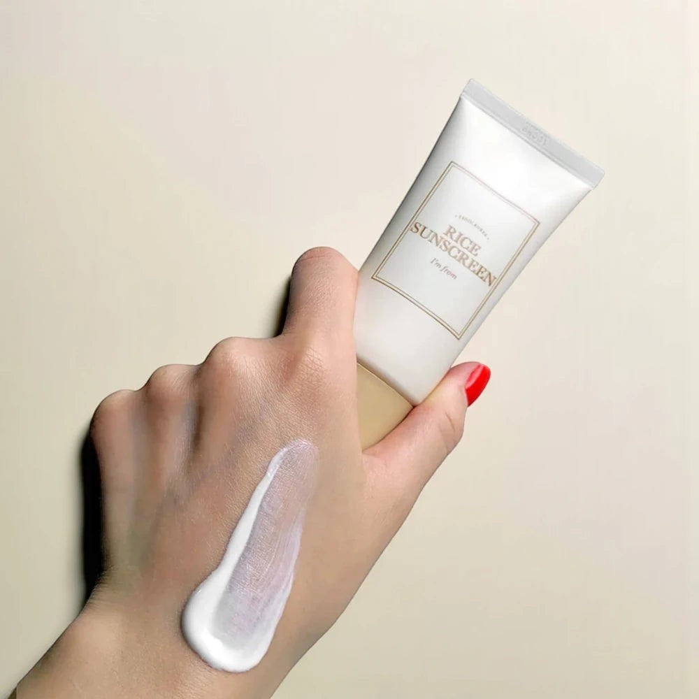 Skin TOGO I'm from Rice Sunscreen SPF50+ tube held in hand with a creamy white product swatch on the skin