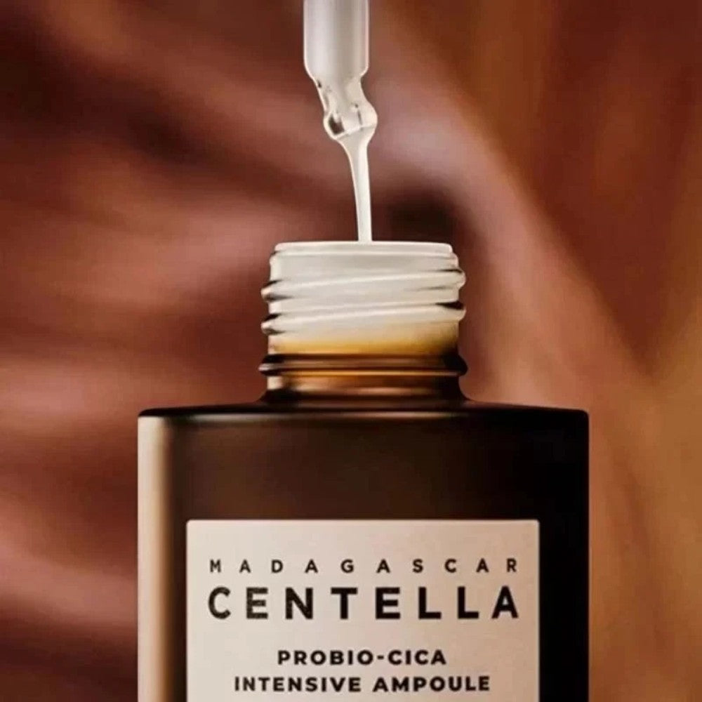 Skin TOGO SKIN1004 Madagascar Centella Probio-Cica Intensive Ampoule with milky serum dripping from a glass dropper.
