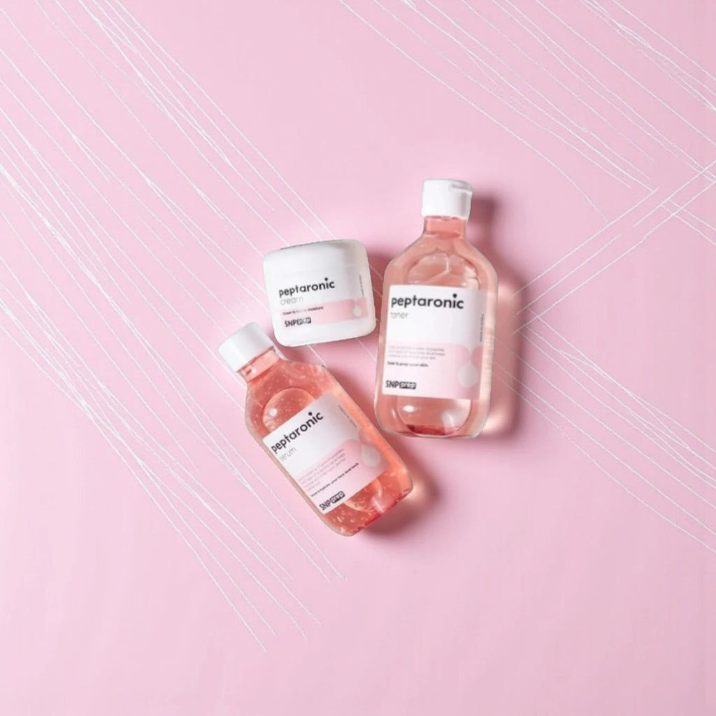 Skin TOGO SNP Prep Peptaronic skincare set including toner, serum, and cream in pink packaging on a pink background.