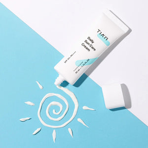 Skin TOGO TIAM Daily Sun Care Cream SPF 50+ in a white tube with cream swirled into a sun shape on a blue background