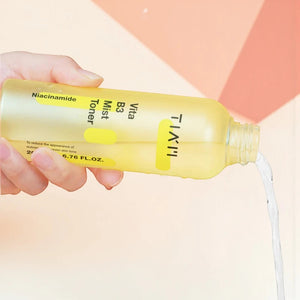 Skin TOGO TIAM Vita B3 Mist Toner being poured from a yellow spray bottle to show its lightweight liquid texture.