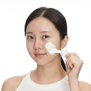 Skin TOGO model applying VT Cosmetics Reedle Shot Hyaluronic Modeling Pack with a white spatula to her cheek
