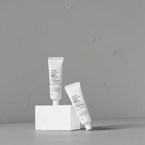 Skin TOGO VT Cosmetics Reedle Shot Synergy Repair Cream tubes displayed on a white block against a grey background.